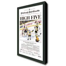 Newspaper displayed in a wood wall frame with glass