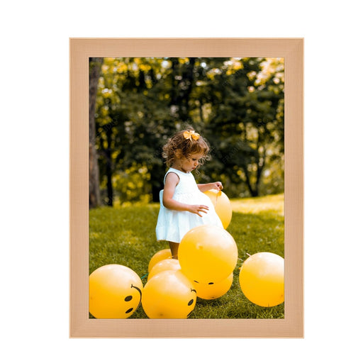 a little girl standing in the grass surrounded by yellow balloons