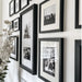 a bunch of black and white pictures hanging on a wall