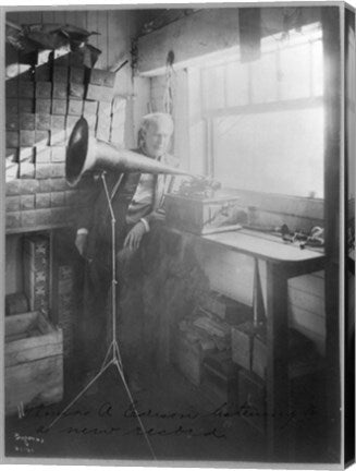 Thomas Alva Edison, full-length portrait, standing, facing right, listening to a new record