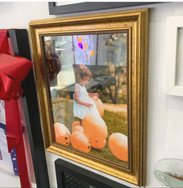 Framed photograph of a child on orange inflatables in a Gold Ornate 36x48 picture frame